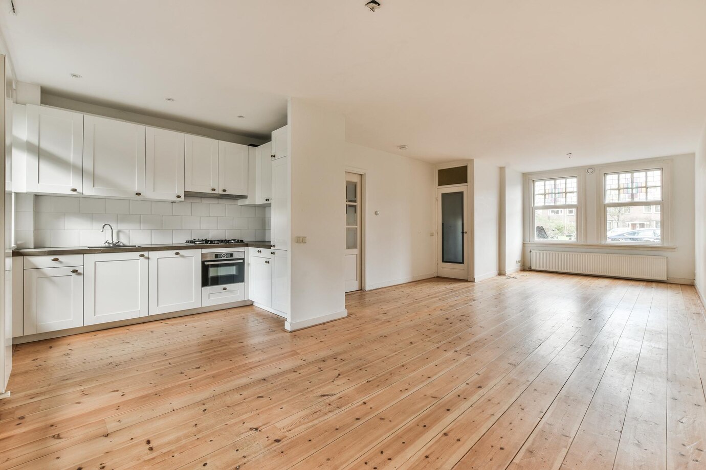 White Kitchen with Wide Plank “Hardwood” Flooring